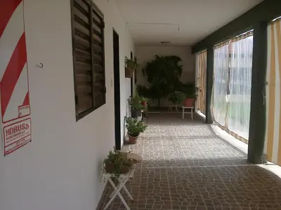 an empty hallway with potted plants on the side of a building at La Nona in Villa Cura Brochero