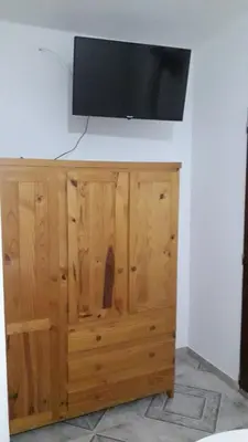 a flat screen tv on top of a wooden cabinet at La Nona in Villa Cura Brochero