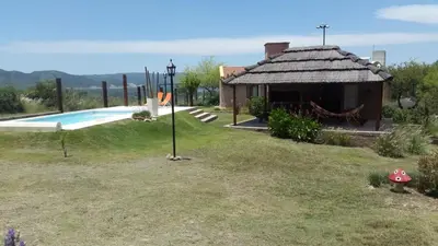 a house with a swimming pool in a yard at Cabañas Villa del Mirador in Bialet Massé