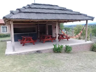 a gazebo with picnic tables and a hammock at Cabañas Villa del Mirador in Bialet Massé