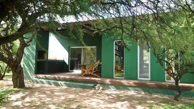 a green house with a bench in front of it at La Simona in Cortaderas