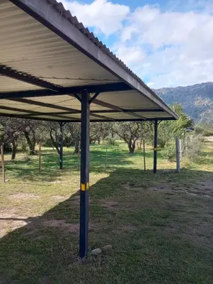 a pavilion in a field with trees in the background at La Simona in Cortaderas