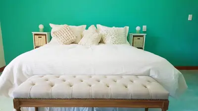 a white bed with a white comforter and pillows at Posada Casa de Piedra in Los Reartes