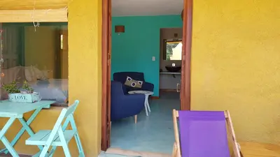 a living room with a blue chair and a table at Posada Casa de Piedra in Los Reartes