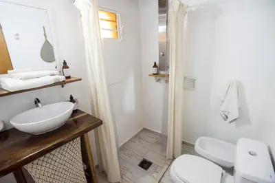 a white bathroom with a sink and a toilet at Posada Casa de Piedra in Los Reartes