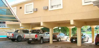 two cars parked in a parking lot in front of a building at Hotel Playa in Villa Carlos Paz