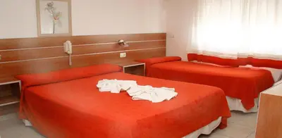 a hotel room with two beds with red sheets at Hotel Playa in Villa Carlos Paz