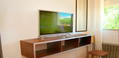 a flat screen tv sitting on top of a entertainment center at Hotel Playa in Villa Carlos Paz