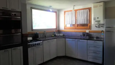 a kitchen with white cabinets and a window at Chalet Nuevo Amanecer in Merlo