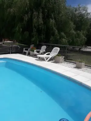 a swimming pool with two chairs and a table and chairs at Chalet Nuevo Amanecer in Merlo