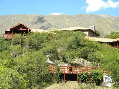 a house on the side of a hill with trees at Cabañas Toay Merlo San Luis in Merlo