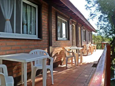 a patio with tables and chairs on a house at Cabañas Toay Merlo San Luis in Merlo