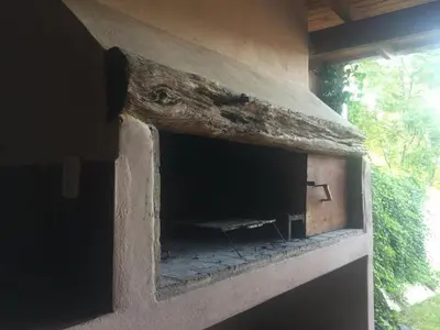 a brick fireplace with a log on top of it at CABAÑA-alojamiento ATAIAS in Santa Rosa de Calamuchita