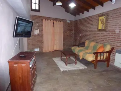 a living room with a couch and a tv at CABAÑA-alojamiento ATAIAS in Santa Rosa de Calamuchita
