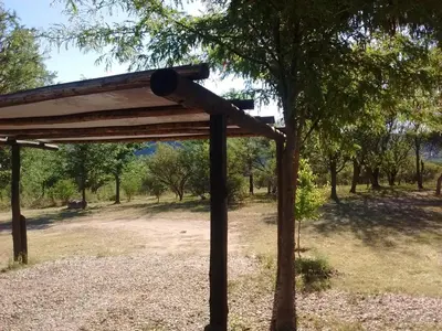 a wooden pergola sitting next to a tree at Las Quimeras in Nono
