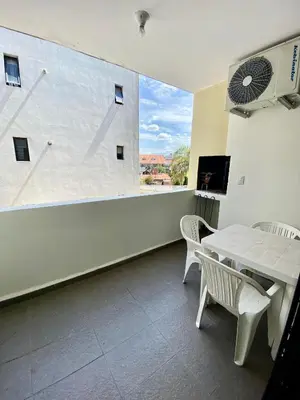 a room with a table and chairs and a large window at Dpto Edificio Tempo in Villa Carlos Paz