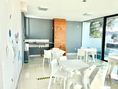 a dining room with white tables and white chairs at Dpto Edificio Tempo in Villa Carlos Paz