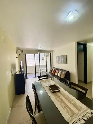 a living room with a table and a couch at Dpto Edificio Tempo in Villa Carlos Paz
