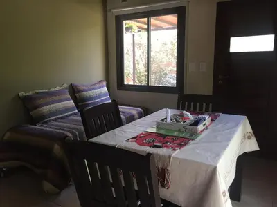 a room with a table and chairs and a bed at Reina de las Cortaderas in Merlo