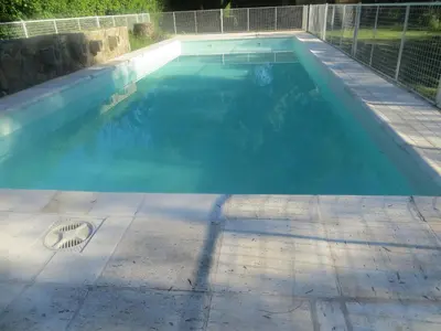 a swimming pool with blue water in a yard at Reina de las Cortaderas in Merlo