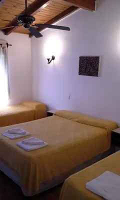 a room with two beds and a ceiling at Amanitas Hotel in Villa Carlos Paz