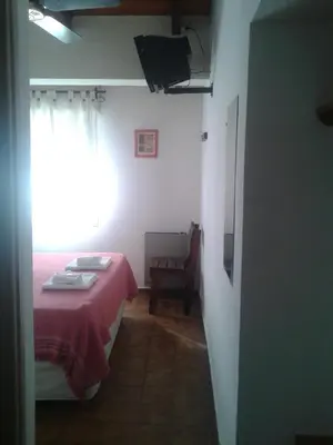 a bedroom with a red bed and a window at Amanitas Hotel in Villa Carlos Paz