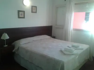 a bedroom with a bed with two towels on it at Amanitas Hotel in Villa Carlos Paz