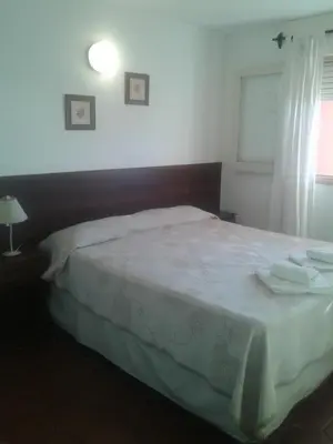 a bedroom with a bed with two towels on it at Amanitas Hotel in Villa Carlos Paz