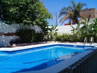 a large blue swimming pool in a yard at Amanitas Hotel in Villa Carlos Paz