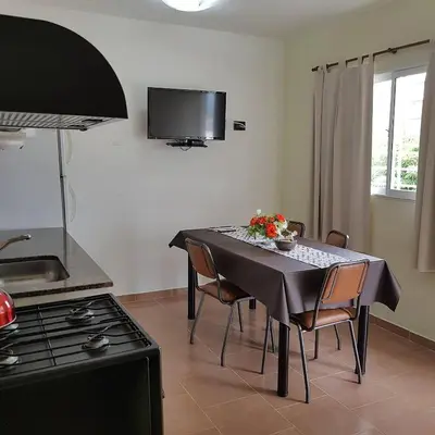 a kitchen with a table with chairs and a stove at Altos del Lago in Villa Carlos Paz