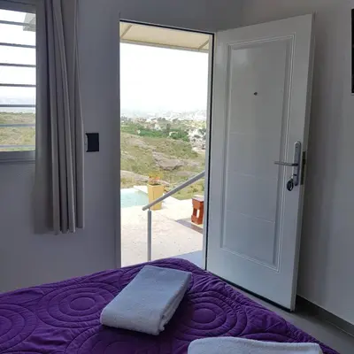 a bedroom with a purple bed and a sliding glass door at Altos del Lago in Villa Carlos Paz