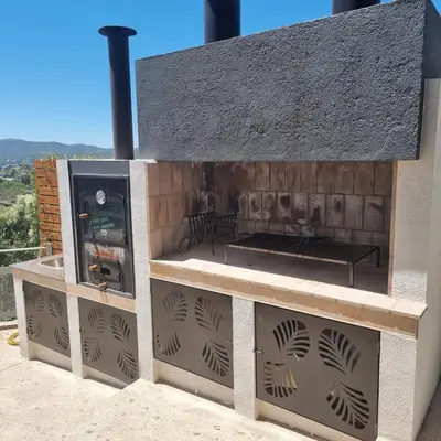 a outdoor pizza oven with a grill on a patio at Altos del Lago in Villa Carlos Paz