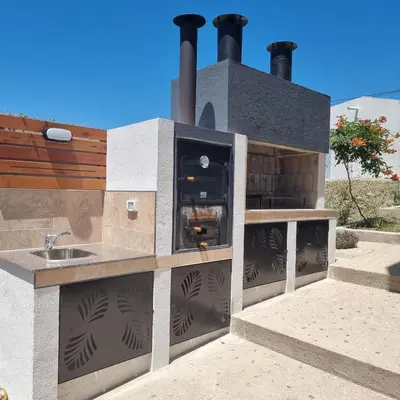 a outdoor kitchen with a stove and a sink at Altos del Lago in Villa Carlos Paz