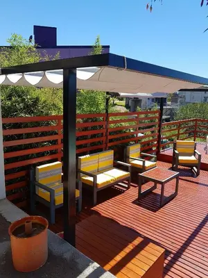 a group of benches and an umbrella on a deck at Altos del Lago in Villa Carlos Paz