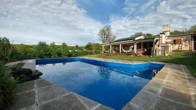 a swimming pool in front of a house at casa de campo en Villa Los Aromos Cordoba in Villa Los Aromos