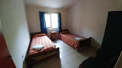 a small room with two beds and a window at casa de campo en Villa Los Aromos Cordoba in Villa Los Aromos