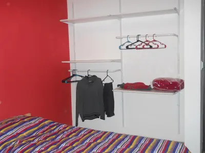 a bedroom with a bed and a red wall at Casa Crisolito in Merlo