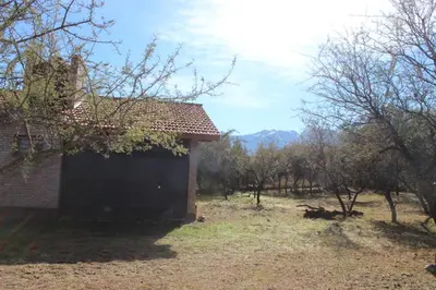 a building in a field next to some trees at Casa Crisolito in Merlo