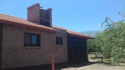a red brick house with a black garage at Casa Crisolito in Merlo