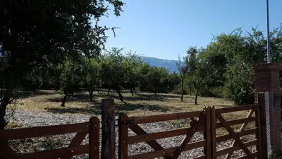 a wooden fence in front of a field with trees at Casa Crisolito in Merlo