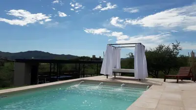 a swimming pool with a chair and a swing at Complejo Joansa in Villa Santa Cruz del Lago