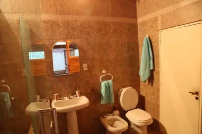 a bathroom with a sink and a toilet and a mirror at Espectacular casa in Cordoba