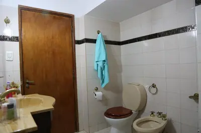 a bathroom with a toilet and a blue towel at Espectacular casa in Cordoba