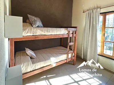 two bunk beds in a room with a window at Cabañas Lomas de Calamuchita in Santa Rosa de Calamuchita