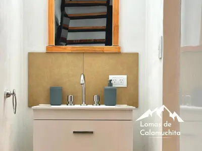 a bathroom with a sink and a mirror at Cabañas Lomas de Calamuchita in Santa Rosa de Calamuchita