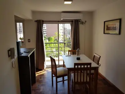 a dining room with a table and chairs and a window at Apartamento Carlucci in Cordoba