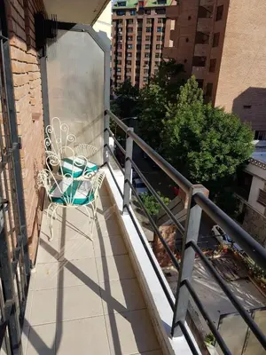 a balcony with a table and a chair on a railing at Apartamento Carlucci in Cordoba