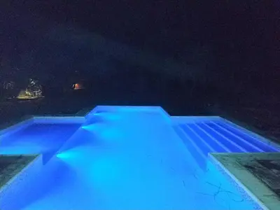 a swimming pool at night with blue lighting at El Naranjero Apart in Carpintería