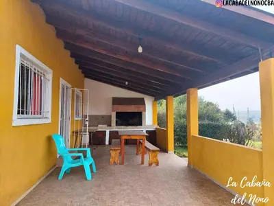 a patio with a table and chairs on a yellow wall at La cabaña del nono in Potrero de Garay