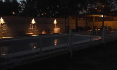 a fence next to a swimming pool at night at El Viejo Vagon in Mina Clavero